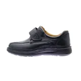 Zapato marrón de cuero con ajuste de velcro y suela negra.