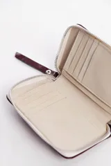 Billetera beige de cuero vacuno con cierre metálico.