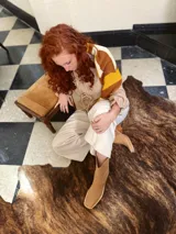 Sweater de punto con diseño geométrico en tonos mostaza, marrón y beige.