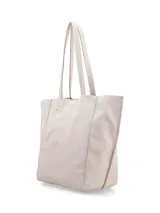 Cartera tipo shopper de cuero color crudo, sin forro y con terminaciones al corte. Presenta gran capacidad y un bolsillo interior con cierre.