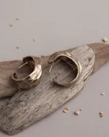 Aros tipo argollas de diseño artesanal con acabado texturizado y forma irregular. Fabricados en bronce y alpaca, con pernos y cierres de plata 925.