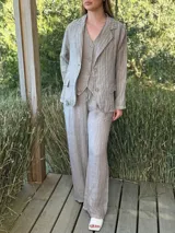 Blazer azul marino con rayas verticales blancas, confeccionado en lino italiano. Tiene botones de coco, solapas clásicas y bolsillos delanteros.