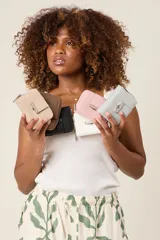 Billetera pequeña de ecocuero con cierre de cremallera y detalle metálico frontal.