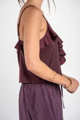 Musculosa negra de satén con escote en V, tirantes finos y detalle de volados en el pecho.