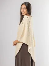Poncho de tejido texturizado en color marrón chocolate, con cuello amplio y diseño asimétrico.