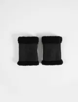 Mitones de color negro con exterior efecto gamuza y bordes de pelo sintético en los extremos.