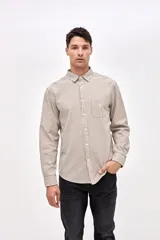 Camisa de corte regular confeccionada en algodón, con diseño de rayas verticales finas en color beige y negro. Presenta cuello clásico, cierre frontal con botones y un bolsillo en el pecho con el logo de la marca bordado.