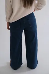 Jean de corte recto y tiro medio, confeccionado en denim azul oscuro. Presenta costuras verticales decorativas a lo largo de cada pierna y diseño de cinco bolsillos.