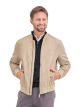 Campera tipo bomber color beige, con cierre frontal, puños y ruedo elásticos acanalados, y bolsillos laterales.