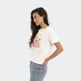 Remera blanca Reef de corte regular fit, con estampa frontal de diseño tropical que incluye palmeras, atardecer y texto.