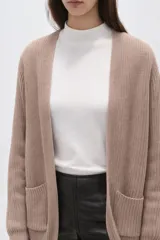 Saco de punto abierto, color rojo, con mangas largas holgadas y diseño de corte amplio.