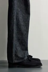 Mocasines de vestir para hombre confeccionados en piel con acabado en serraje de color azul marino, con detalle de borlas en el empeine y suela con ligero tacón.