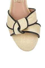Sandalias beige con taco cuadrado mediano y tira al tobillo negra.