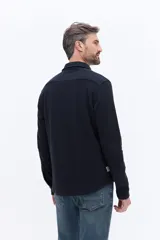 Camisa de manga larga color azul marino, confeccionada en algodón con textura, cuenta con un bolsillo frontal y cierre frontal con botones.
