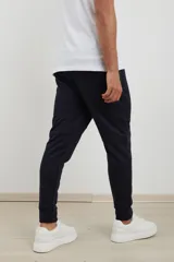Pantalón jogging de corte slim, con puños elastizados, cintura con cordón ajustable, cierres laterales engomados y bolsillo tipo parche lateral.