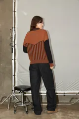 Campera de punto con cierre frontal, diseño bicolor en tonos bordó y rojo, con mangas largas y textura combinada de tejido liso y acanalado.