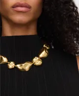 Collar de piezas metálicas con diseño de formas orgánicas en color dorado y cierre de mosquetón.