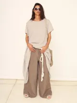 Pantalón palazzo ancho de lino color visón, con cintura alta y cordón de ajuste.