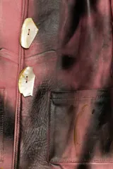 Blazer de cuero color rosa con manchas negras, intervenido con arte abstracto.