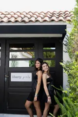 Minivestido negro con estampado abstracto en tonos grises y blancos. Presenta escote halter con abertura en el pecho, corte a la cintura y falda con volados.