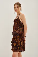 Falda corta con volados, confeccionada en tela estampada con diseño abstracto en tonos marrones y ocres.