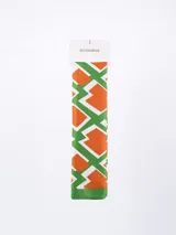 Pañuelo de forma rectangular con estampado geométrico en tonos naranja, verde y blanco.