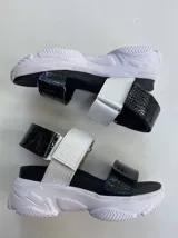 Sandalias con plataforma blanca y tiras de cuero sintético con textura de cocodrilo en blanco y negro.