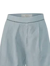 Short celeste de lino orgánico y viscosa, de tiro medio con pinzas delanteras y detalles de bandas con perforaciones geométricas en la cintura y los dobladillos.