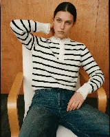 Sweater de punto a rayas horizontales marrones y blancas, con cuello redondo, cierre frontal parcial con botones y detalles de puntilla blanca en el cuello y los puños.