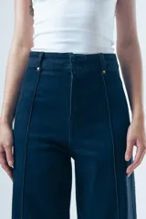 Jean de corte recto y tiro alto, color azul oscuro, con costuras verticales decorativas en el frente y diseño de pierna ancha.