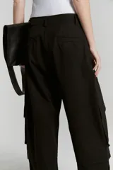 Pantalón negro de gabardina de algodón, corte ancho, con cintura sastrera, bolsillos delanteros con pinzas, bolsillos 3D plaque con tapa y pestaña en el recorte de la pierna.