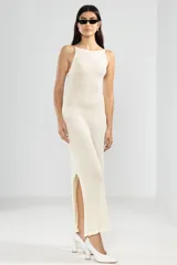 Vestido largo tejido color crema, con cuello halter y espalda baja.