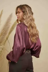 Blusa de satén color champagne con cuello a la base, mangas anchas y puños elásticos con detalle bordado.