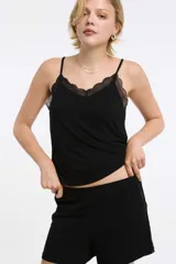 Musculosa de rib color negro, con breteles finos regulables, escote en V y detalles de encaje en el escote y las sisas.