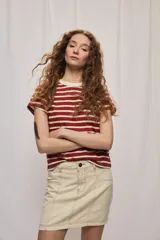 Falda de denim blanca de corte recto con bolsillos delanteros aplicados, costuras pespunteadas a contratono y cierre frontal con botón y cremallera.