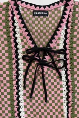 Vestido corto de punto sin mangas con diseño de damero en tonos rosado, verde y blanco, escote en V con cordones negros para ajustar y detalles de rayas verticales.