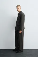Blazer de corte relajado confeccionada en lana de origen italiano, con diseño de doble botonadura cruzada. Presenta cuello con solapas de muesca, manga larga con botones en puños, bolsillos con solapa en la cadera y abertura central en la espalda. Incluye forro interior a contraste.