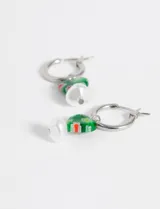 Par de caravanas plateadas tipo argolla con dije de corazón de vidrio verde con detalles rojos y blancos, y dije de perla blanca.