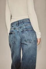 Jeans de tiro alto con corte tapered y largo al tobillo. Presenta cinco bolsillos, trabillas en la cintura, cierre frontal con cremallera y botón, y detalle de raya planchada en el delantero.