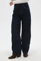 Pantalon de jean azul oscuro con corte barrel, cintura media con cordón ajustable y costuras a la vista en contraste.