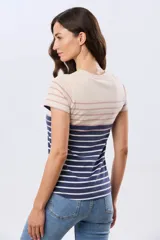 Remera de manga corta y cuello redondo, confeccionada en algodón con diseño de rayas horizontales en tono beige, rosado y azul marino.