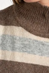 Polera de tejido de punto con diseño a rayas horizontales en tonos marrón, beige y gris. Presenta cuello alto, mangas largas con puños anchos y un corte holgado.
