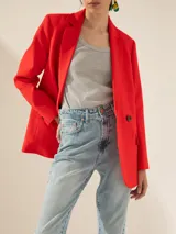 Blazer rojo de lino, cruzado, con solapas de muesca, dos botones de pasta a tono en el cruce y botones en los puños.