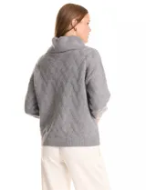 Buzo de punto grueso con textura en relieve, de cuello volcado y mangas largas con hombros caídos. Presenta puños y ruedo con terminación en rib.