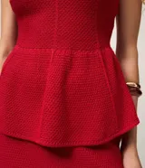 Blusa peplum de punto color rojo, sin mangas, con breteles anchos y escote redondeado.