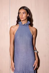 Vestido largo negro de crepe texturado con escote halter, cuello alto con volados y diseño holgado.