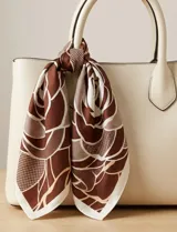 Pañuelo cuadrado de seda con estampado floral en tonos verde, blanco y negro.