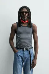 Camiseta sin mangas de corte regular, confeccionada en tejido de algodón con elasticidad. Presenta un diseño de rayas horizontales finas, cuello redondo y acabados en vivo doble.