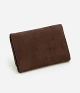 Billetera femenina de tamaño mediano con formato sobre y estructura firme. Presenta un acabado texturizado en color marrón y cuenta con una placa metálica decorativa con el logo de la marca en la parte frontal.