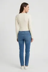 Sweater corto de punto rib en color tostado, con escote redondo a la base y mangas largas ajustadas.